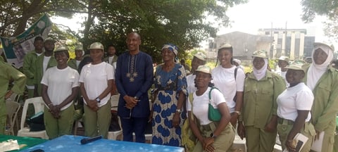 Group of people in work uniforms and casual attire standing together outdoors during what appears to be an official gathering or event